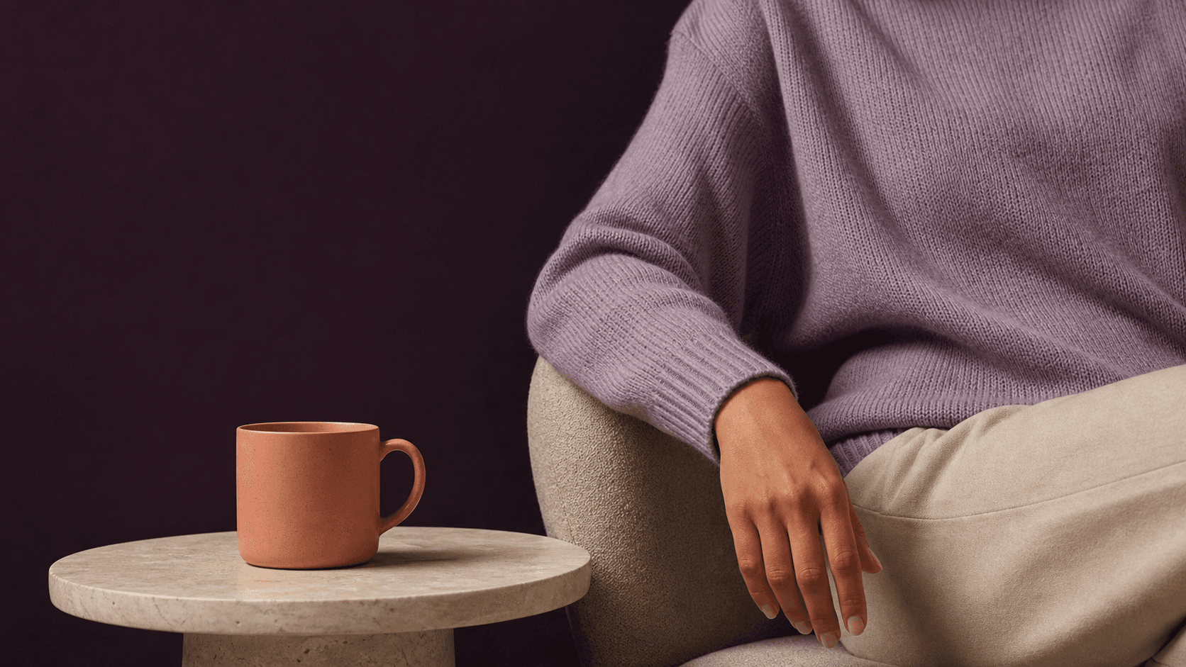 A quiet pause with a warm mug beside a seated person